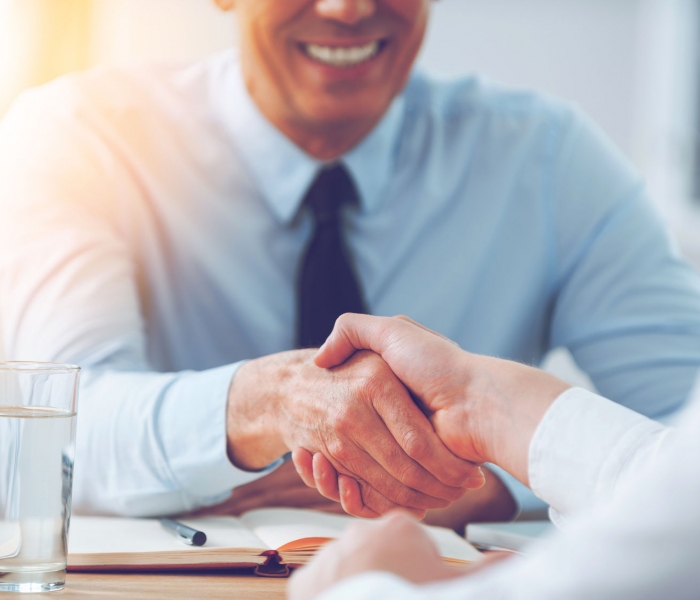 54625309 - good deal. close-up of two business people shaking hands while sitting at the working place
